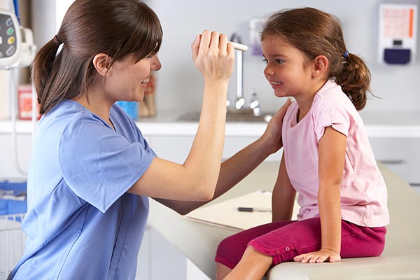 doctor checking child's eyes